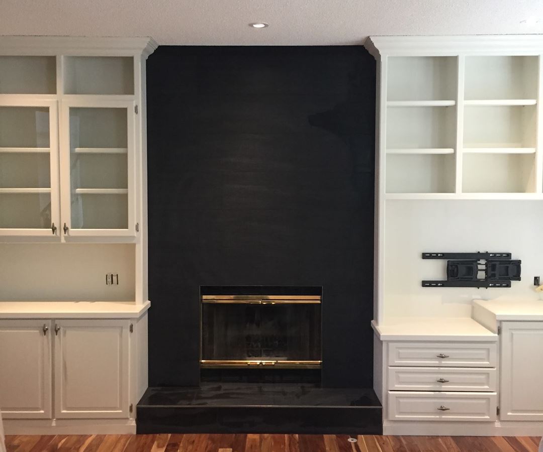 Striking black accent wall between painted white built-in cabinetry